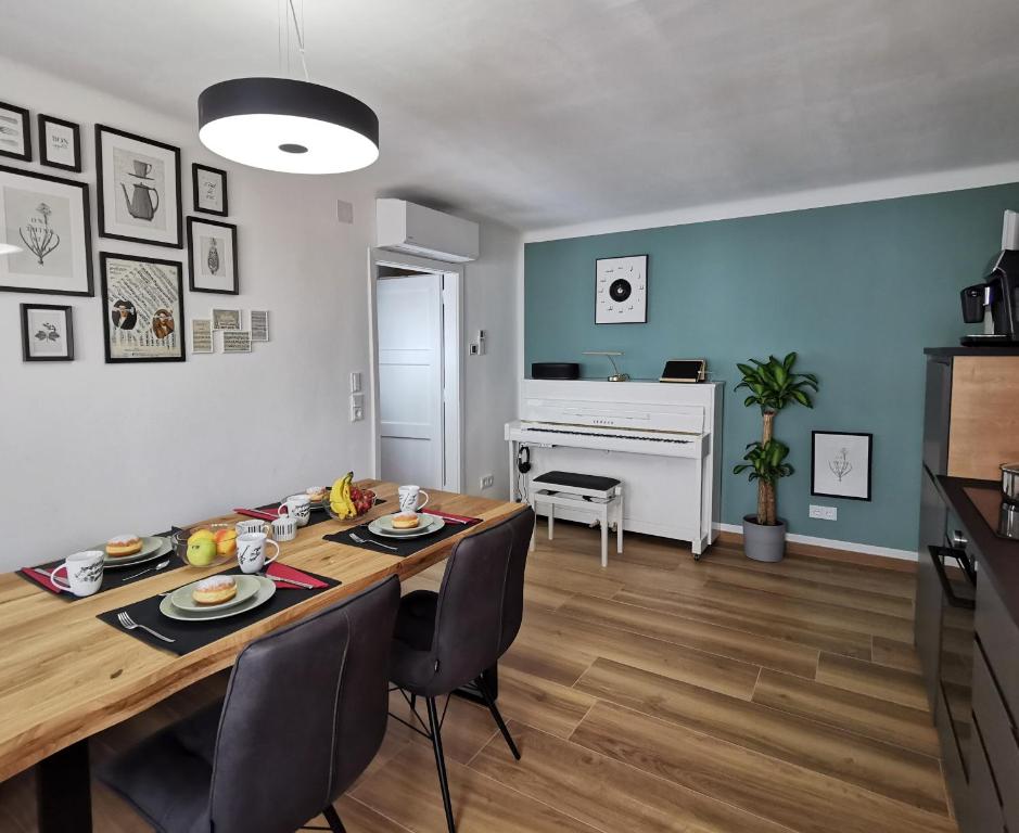 a living room with a dining room table with chairs at Neues City Center Piano Appartement mit Netflix in Klagenfurt