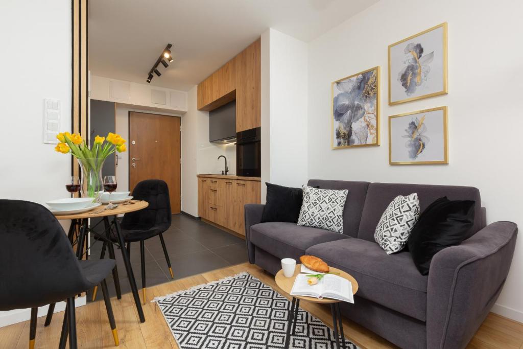 a living room with a couch and a table at Warsaw Praga Kokoryczki Apartments with Parking by Renters in Warsaw