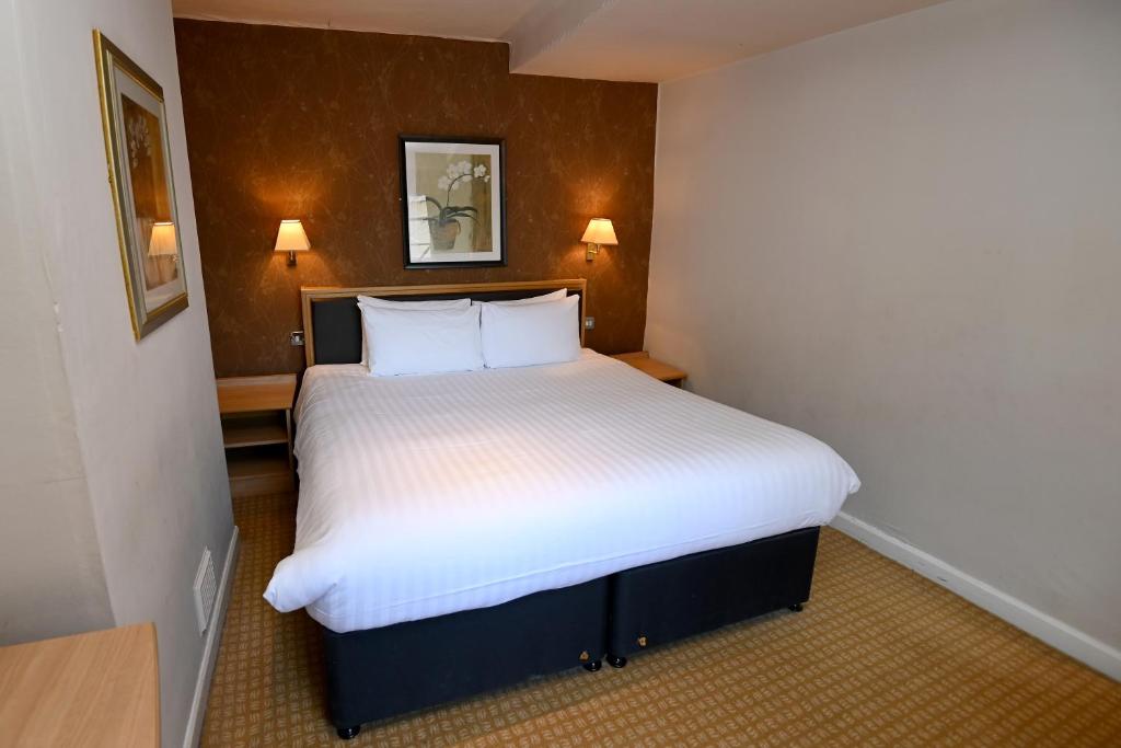 a bedroom with a large white bed with two pillows at The Vine hotel by THEGREATVINE Ltd in Stafford