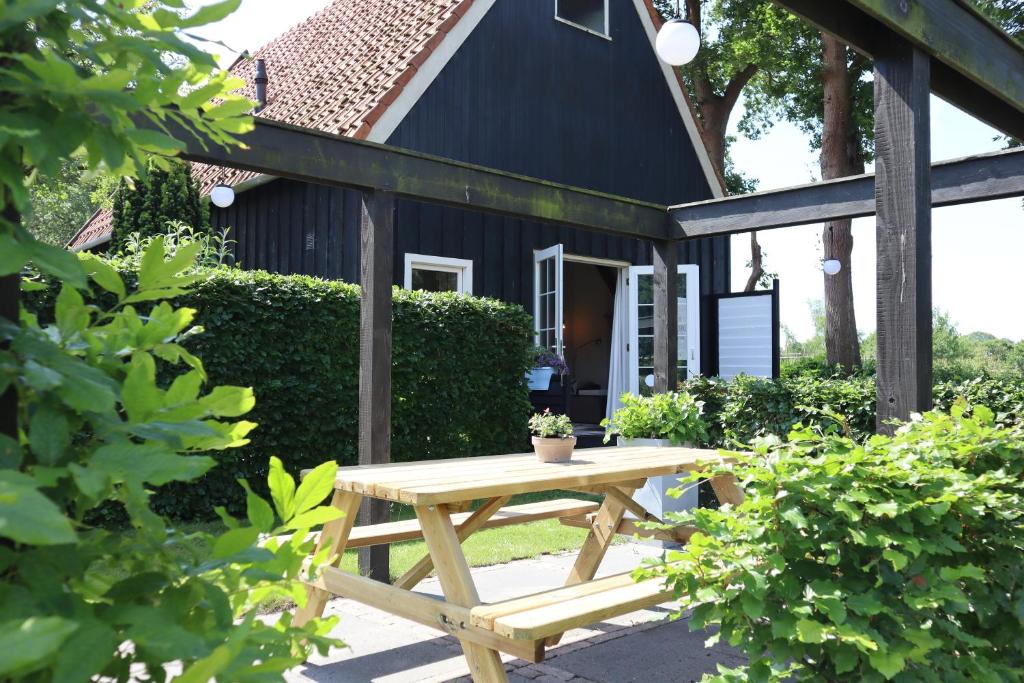 una mesa de picnic frente a una casa en B&B Woudzicht, en Oudeschoot