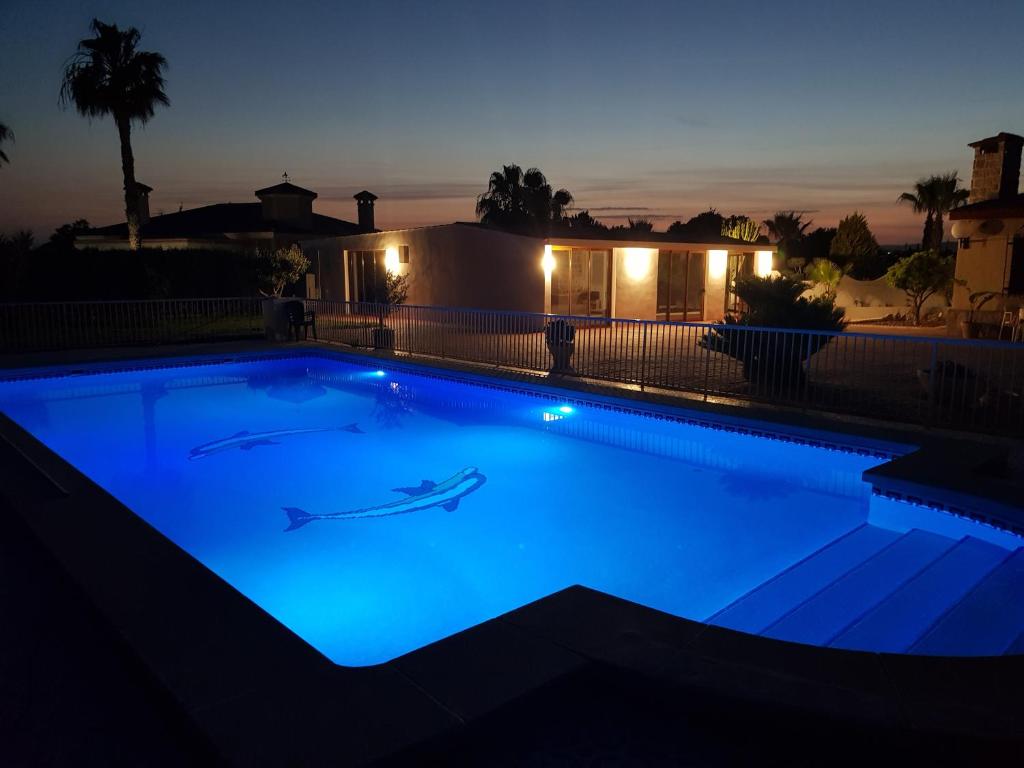 una piscina iluminada por la noche en VILLAMÓNICA, en Torrellano