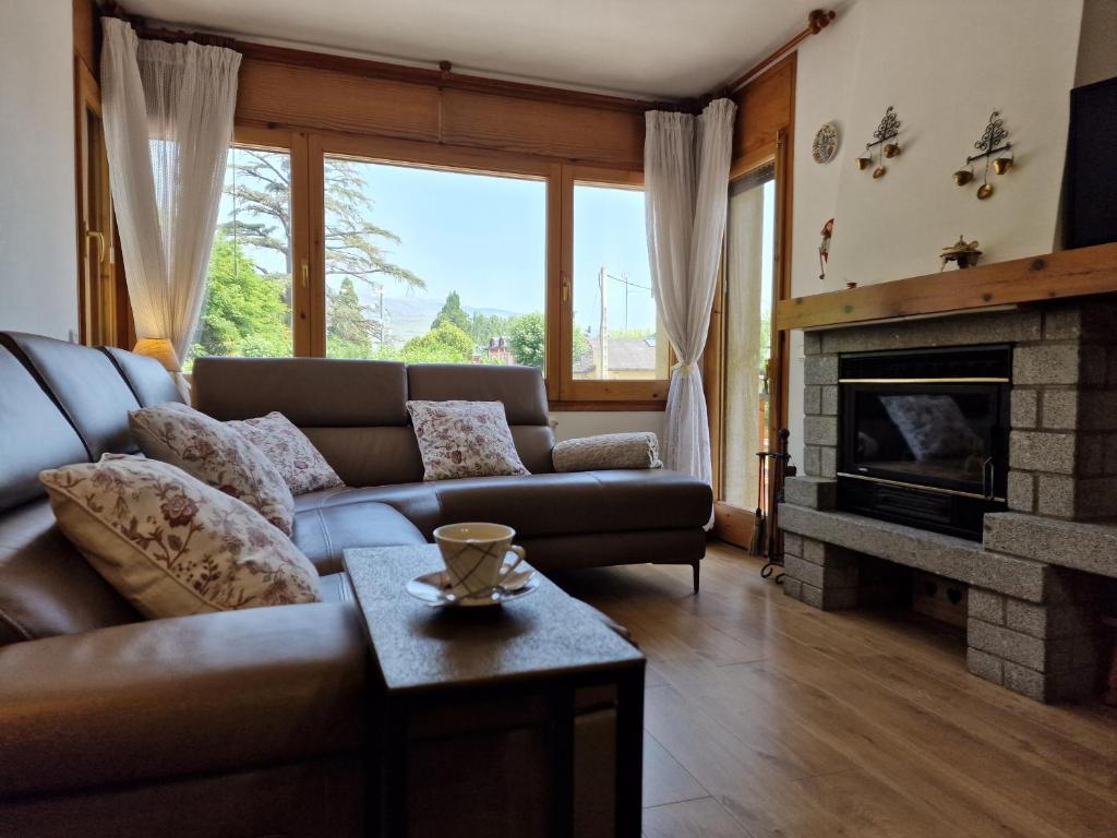 ein Wohnzimmer mit einem Sofa und einem Kamin in der Unterkunft Mariajo’s House in Puigcerdà