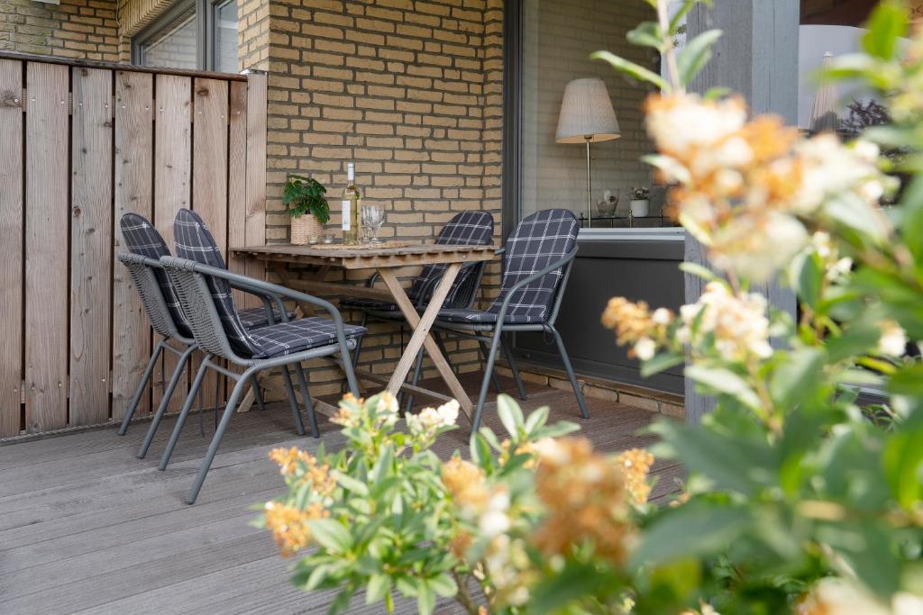 a patio with a table and chairs on a deck at Blankwasserweg 131 Lensterstrand Oase Bungalow 4 in Lenste
