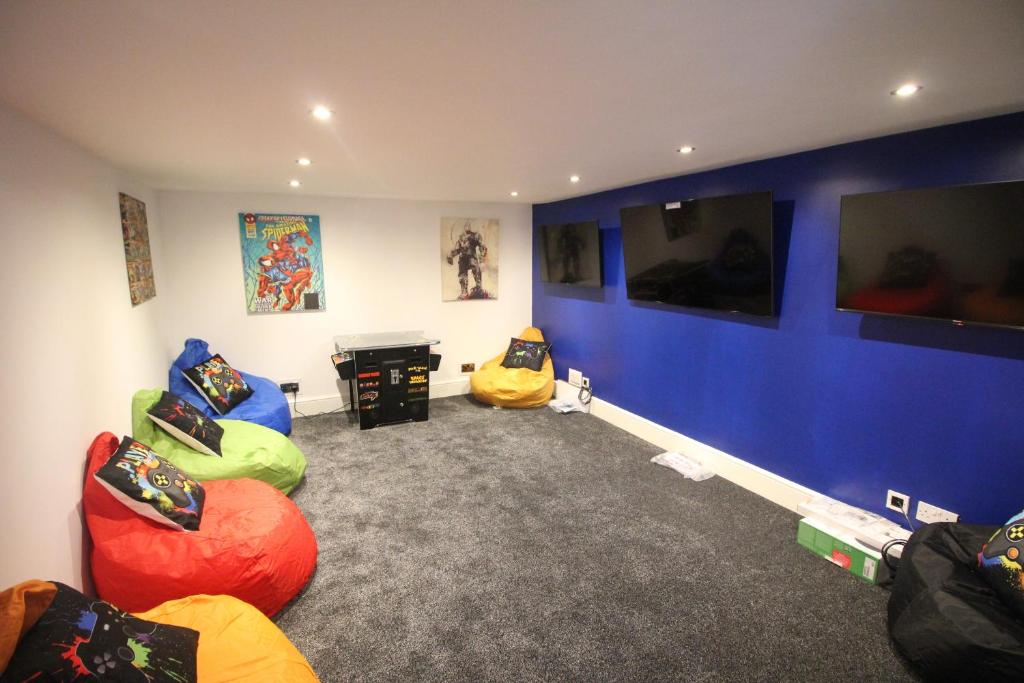 a room with chairs and a table and a blue wall at Media Manor - Fully Refurbished in 2022 - Large 6 Bedrooms, 3 Bathrooms plus Media Games Room in Blackpool