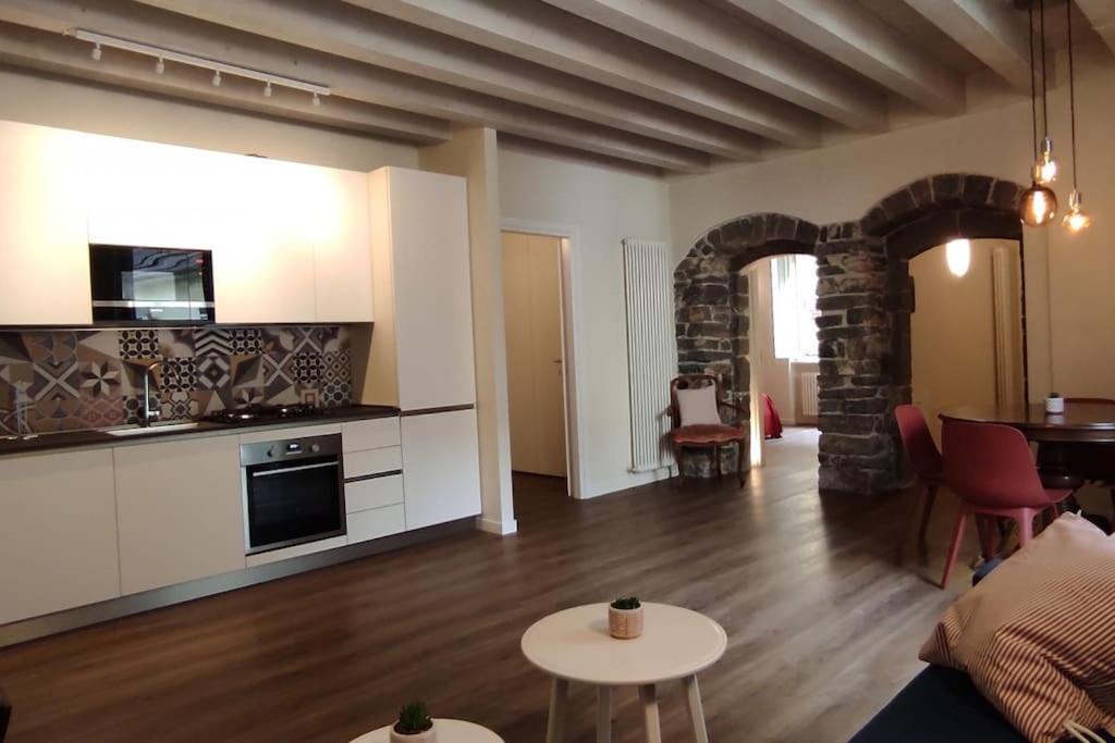 uma sala de estar com uma cozinha e uma sala de estar com uma mesa em MARGHERITA'S HOME em Lovere