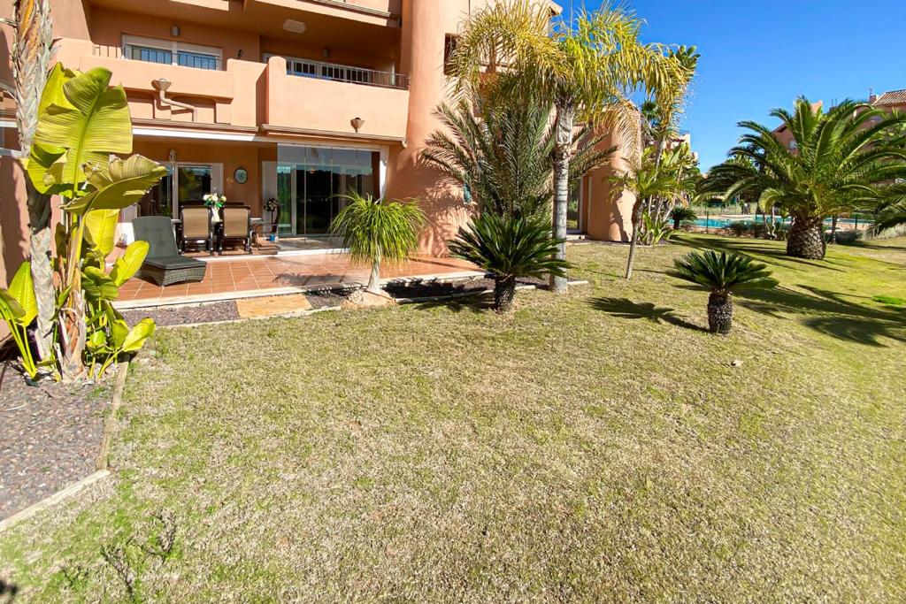 einen Hof mit Palmen und einem Haus in der Unterkunft Luxury South Facing Groundfloor Apt in Torre-Pacheco
