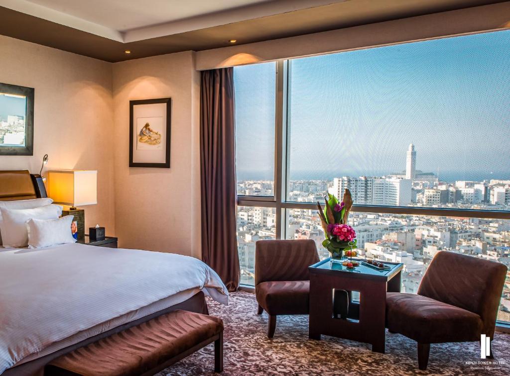 Cette chambre comprend un lit et une grande fenêtre. dans l'établissement Kenzi Tower Hotel, à Casablanca