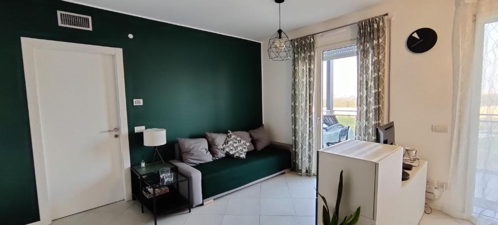 un soggiorno con parete verde e divano di Bloom Modern House - Milano a Milano