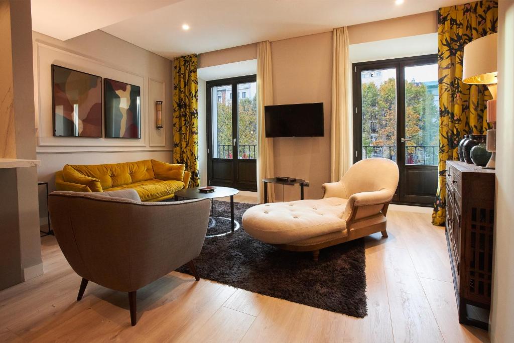uma sala de estar com um sofá e uma cadeira em U-Sense Madrid Santa Ana em Madri