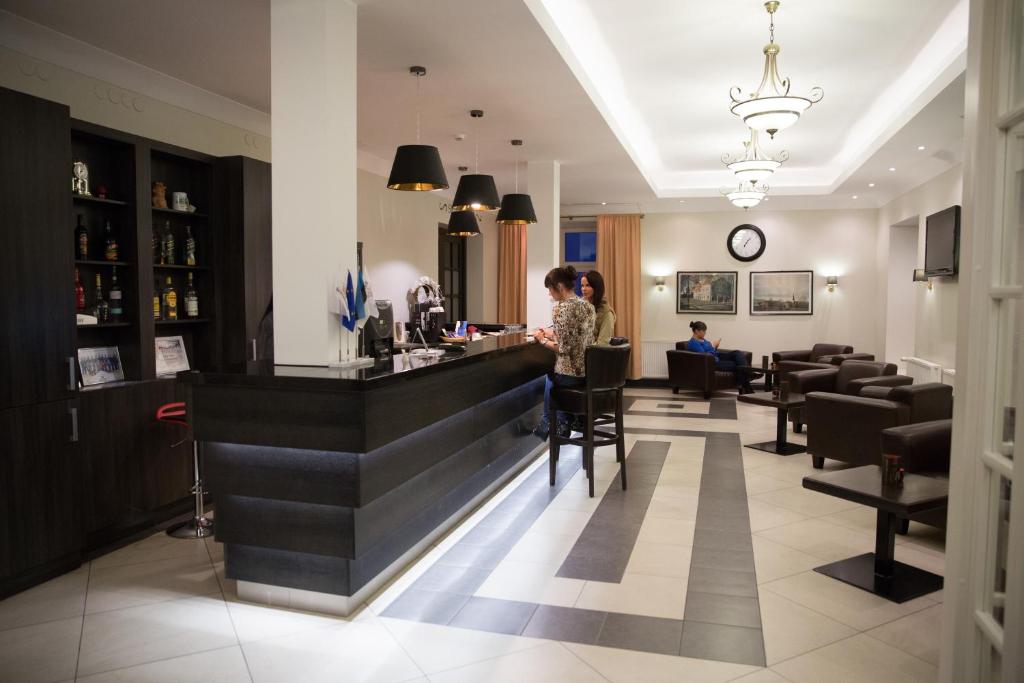 a bar in a restaurant with people sitting at it at Hotell Wesenbergh in Rakvere