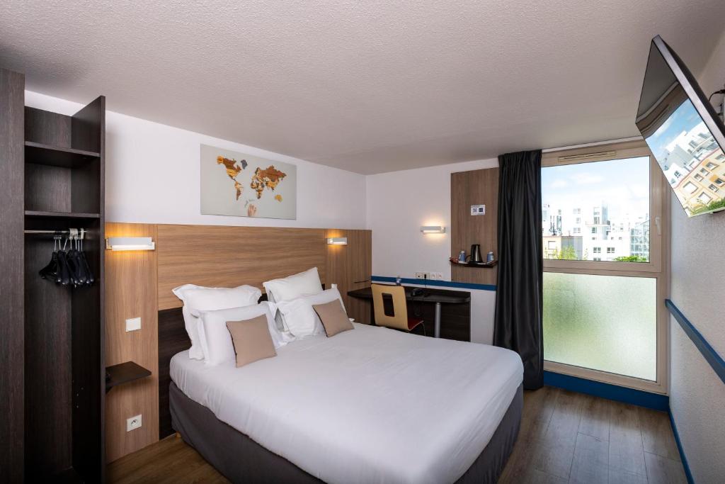 a hotel room with a large bed and a window at Kyriad Paris Ouest - Colombes in Colombes