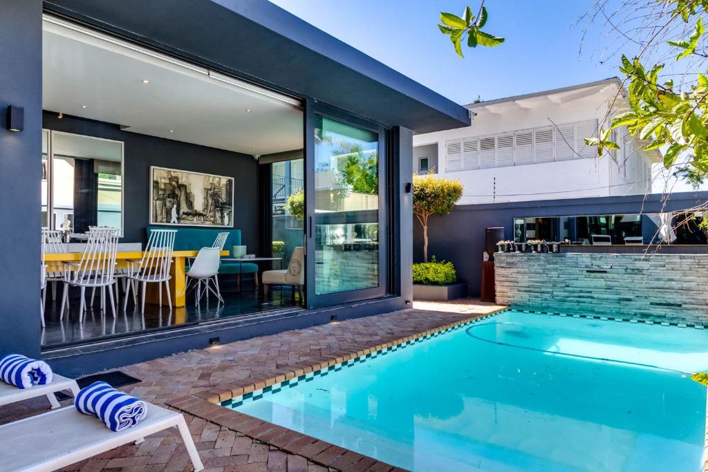 a swimming pool in the backyard of a home with a house at Life & Leisure Boutique Guesthouse in Stellenbosch