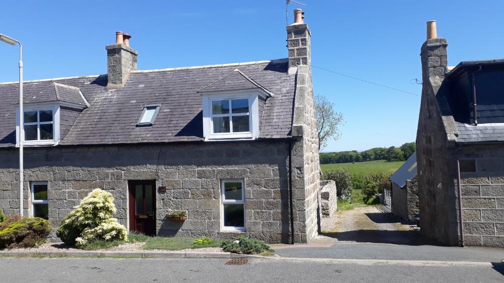 uma antiga casa de pedra no campo em Paula's Cottage em New Pitsligo