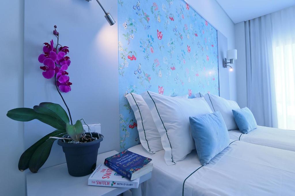 een woonkamer met een witte bank en een plant bij Agua Hotels Alvor Jardim in Alvor