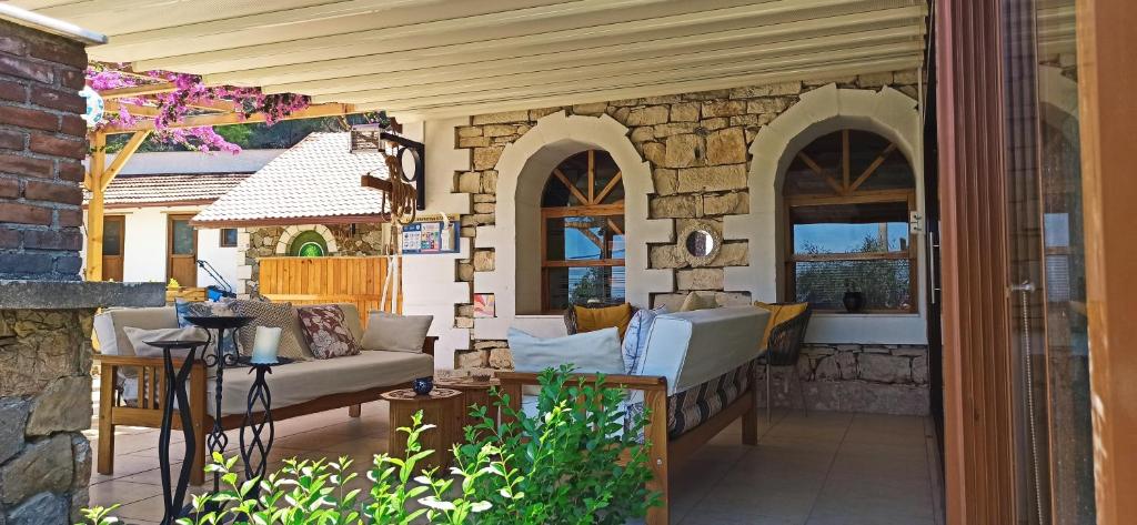 a porch with a couch and chairs on a patio at Swiss Eviniz Hotel in Adrasan