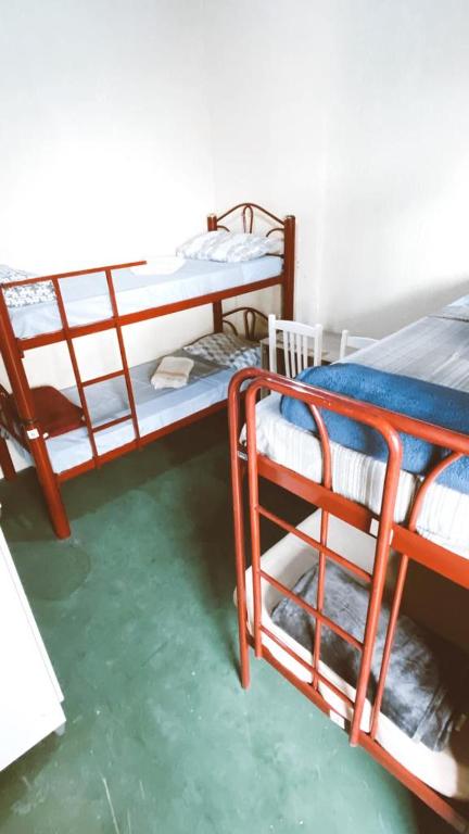 a room with two bunk beds and a green floor at Hostel Dona Lucia in São José dos Campos
