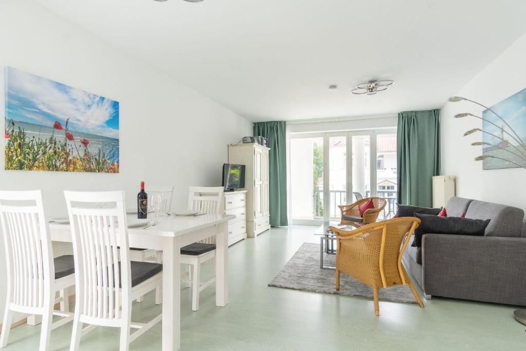 ein Wohnzimmer mit einem weißen Tisch und Stühlen in der Unterkunft Neubau Villa Strandidyll Typ 4 / Apartment 1.2 in Binz