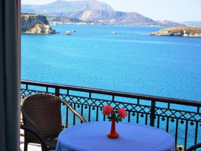 una mesa con un jarrón de flores en el balcón en Isadora, en Almyrida