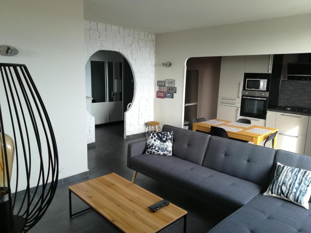 een woonkamer met een bank en een tafel bij Tout confort Toulon centre appartement 3 chambres, vue sur la Rade in Toulon