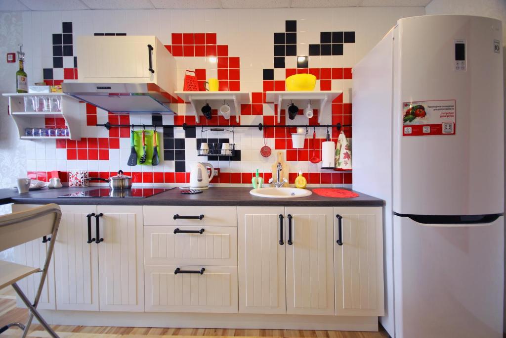 a kitchen with a red and black tile wall at FullHouse Hostel in Belgorod