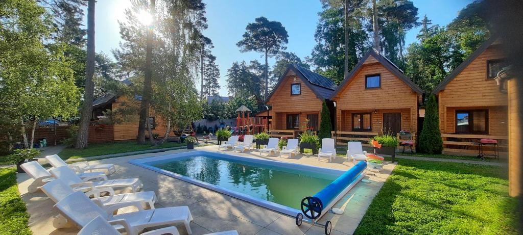 una casa con piscina con sedie e scivolo d'acqua di Ośrodek 9Amber a Pobierowo