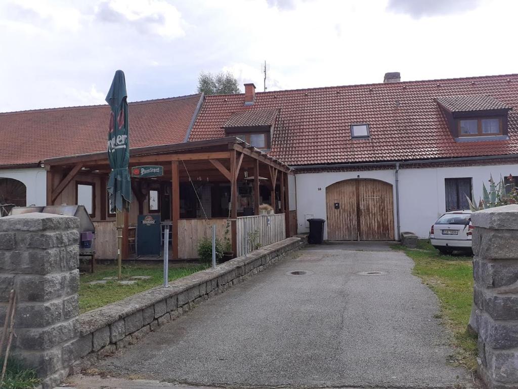 ein Haus mit einer Holzgarage und einem Gebäude in der Unterkunft Penzion Na Zámostí Malenice in Malenitz