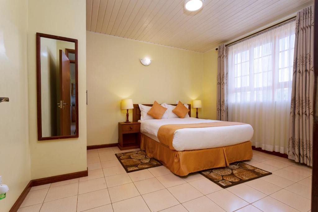 una camera con un grande letto e una grande finestra di The Cycads Suites a Nairobi