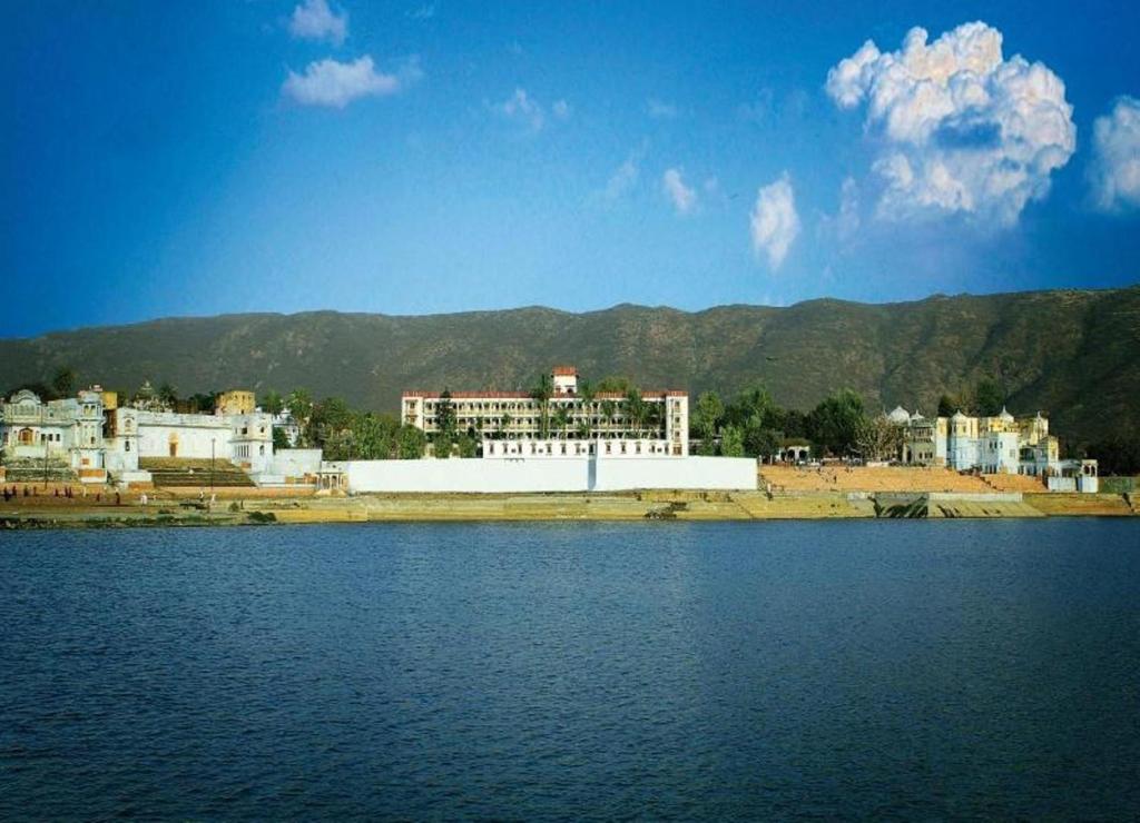 un grupo de edificios a orillas de una masa de agua en Hotel Pushkar Palace, en Pushkar
