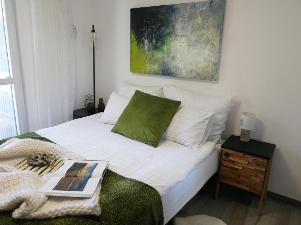 een slaapkamer met een bed met een boek erop bij Apartma Medoši in Izola