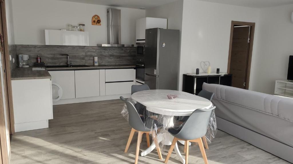 een keuken met een tafel en stoelen en een bank bij Jolie petite maison à 50 mètres de la plage in Cap d'Agde