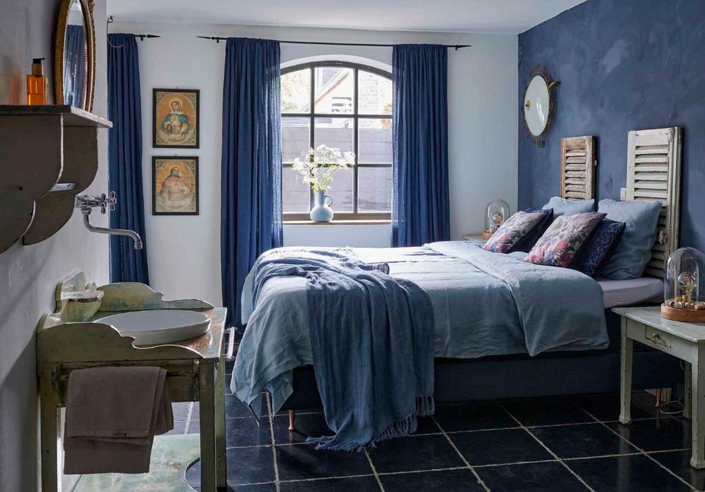 a blue bedroom with a bed and a sink at Gasterie Lieve Hemel in Sevenum