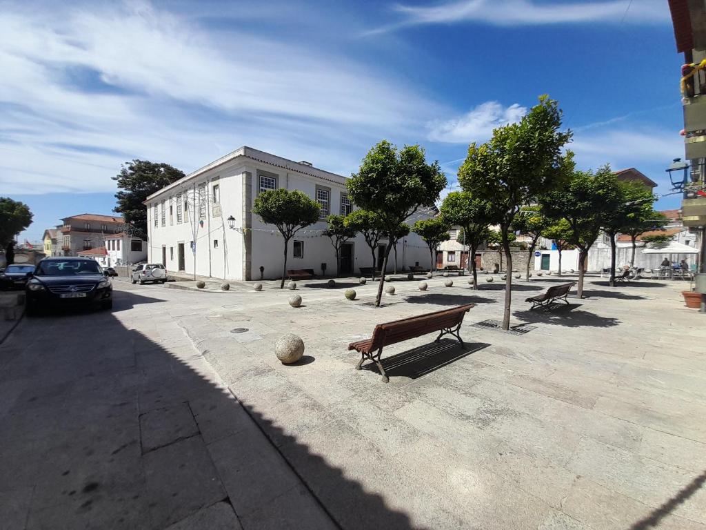 um parque com bancos e árvores e um edifício em Laranjal Guesthouse em Vila do Conde