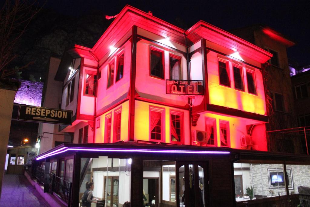 un edificio iluminado en rojo y amarillo en Sehrizade Konagi, en Amasya