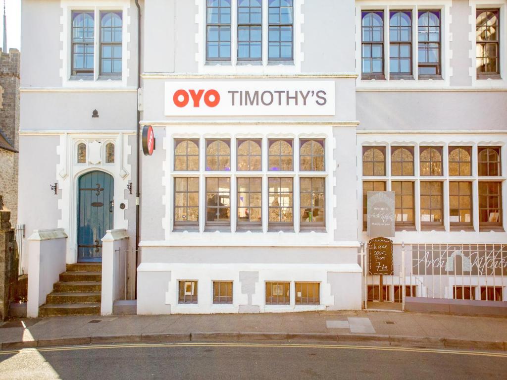 a white building with a sign that reads oxo timneys at OYO Timothy's in Tenby