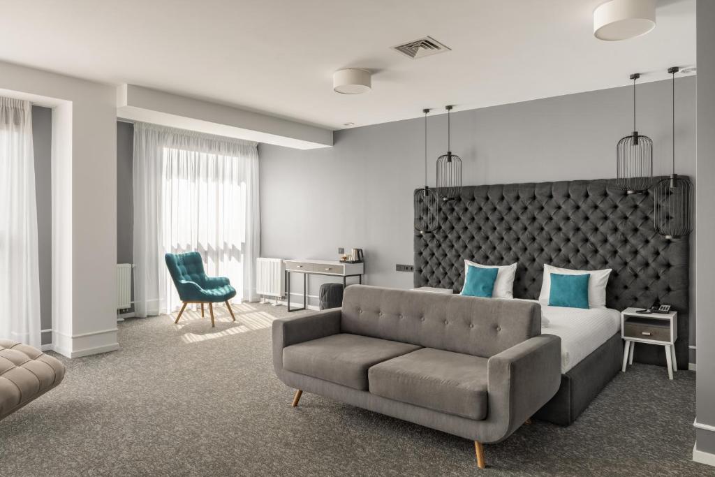 um quarto com uma cama, um sofá e uma secretária em City Inn Lviv Smart Hotel em Lviv