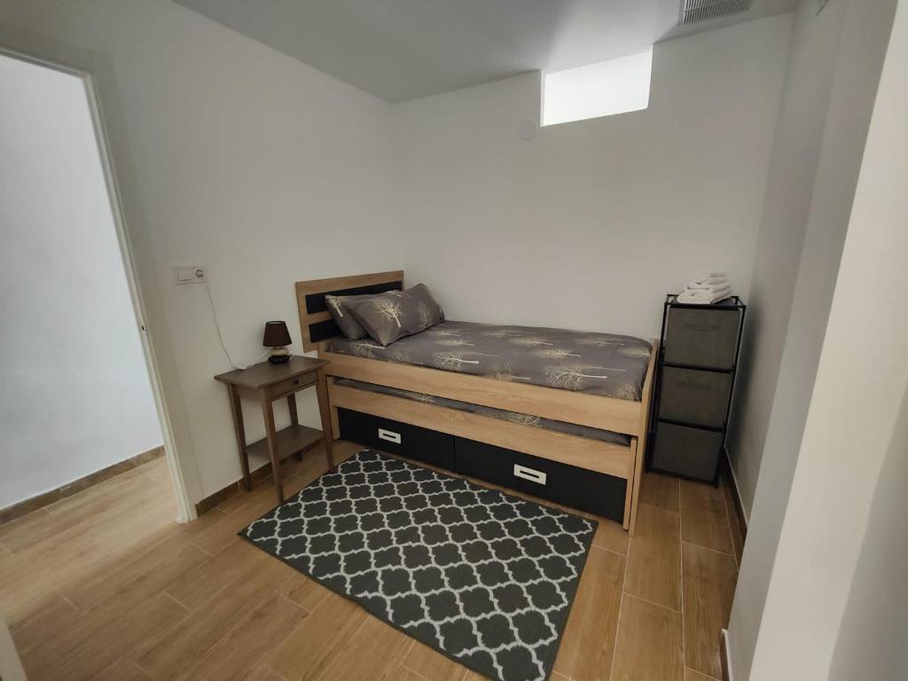 a small bedroom with a bed and a rug at Casa Aigua Blanca Oliva in Oliva