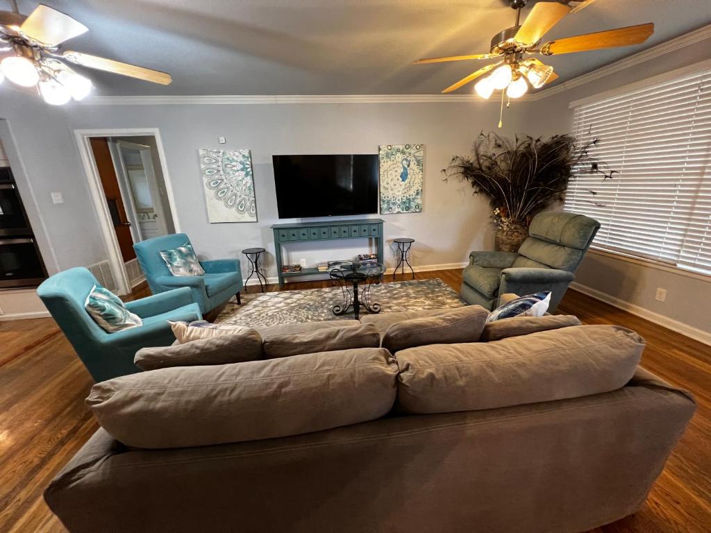 uma sala de estar com um sofá grande e duas cadeiras em The Peacock House em San Antonio