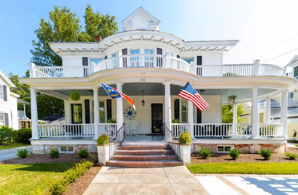 a white house with two american flags on it at The Edenton Collection-Captain's Quarters Inn in Edenton