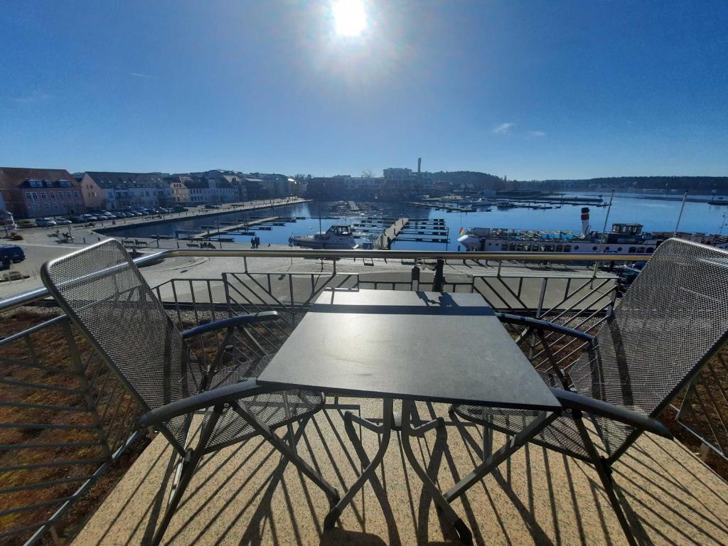 - Balcón con mesa y sillas y vistas al río en Ferienwohnung "Waren am Hafen" Objekt-ID 11992-8, en Waren