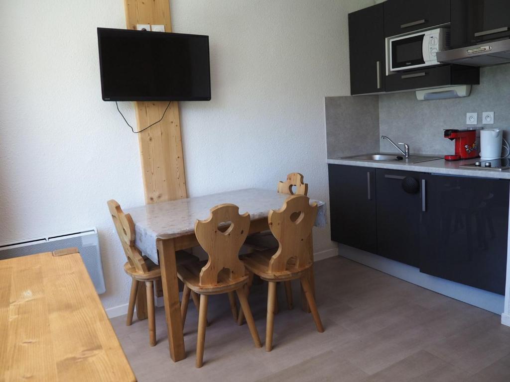 - une cuisine avec une table et des chaises en bois dans l'établissement Studio rénové proche des pistes avec balcon - Tout équipé, 3 pers., 2 flocons or - FR-1-344-180, aux Menuires