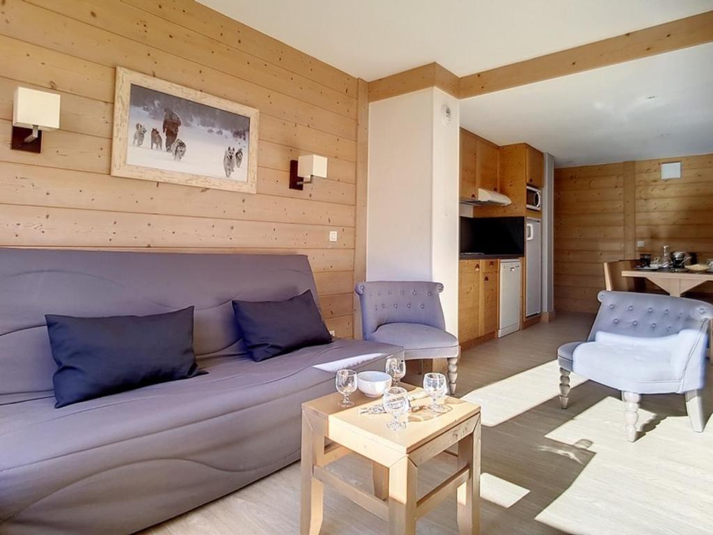 ein Wohnzimmer mit einem Sofa und einem Tisch in der Unterkunft Appartement Les Menuires, 3 pièces, 8 personnes - FR-1-344-345 in Les Menuires