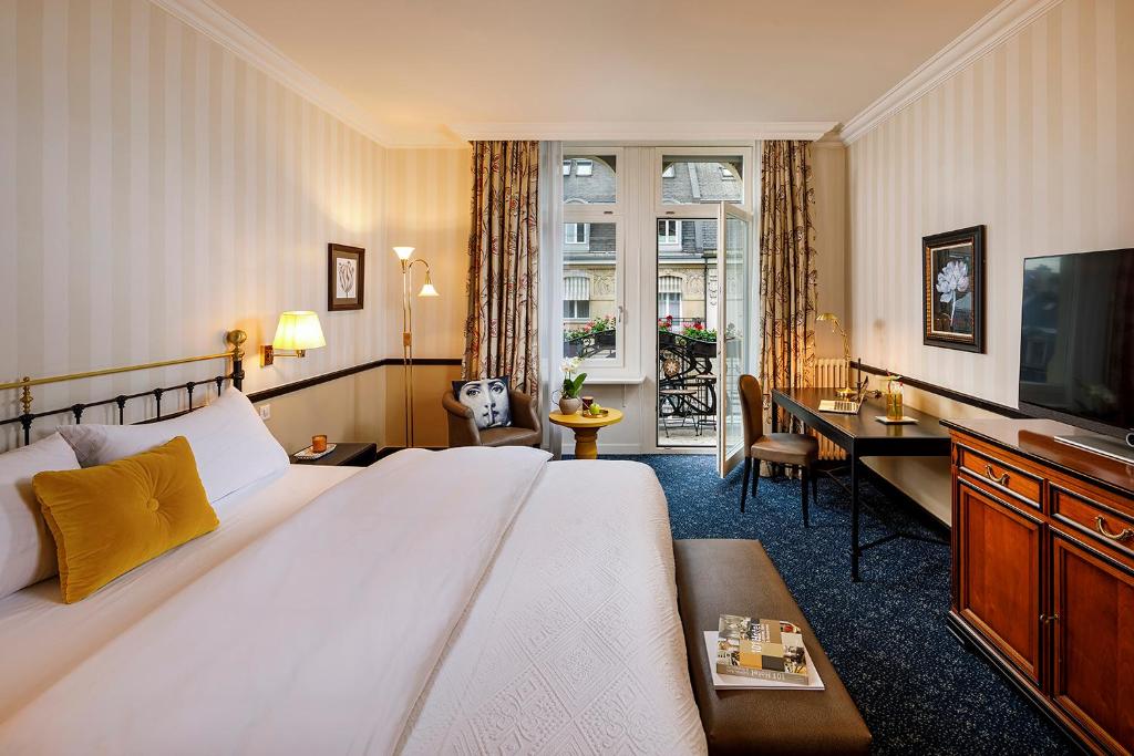a hotel room with a large bed and a desk at Opera Hotel Zürich in Zürich