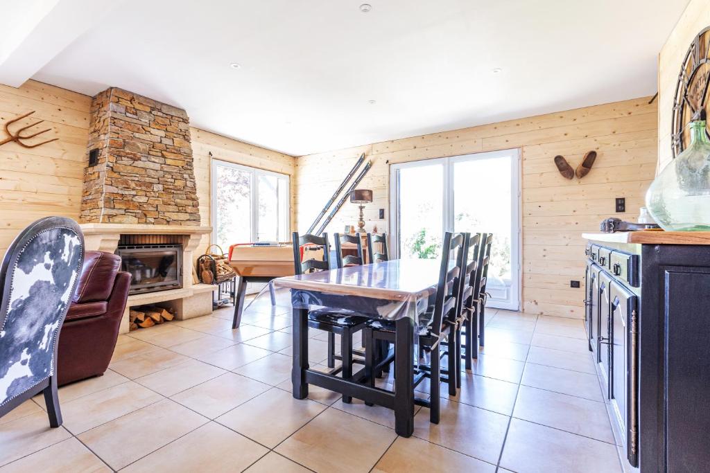 a kitchen with a table and chairs and a fireplace at La Granja - Maison avec cheminée, jardin, baby-foot in Formiguères