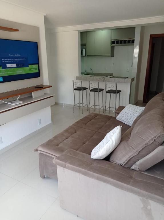 un salon avec un canapé et une télévision à écran plat dans l'établissement Lindo apartamento 1 quarto próximo a Rua de Lazer Domingos Martins, à Domingos Martins