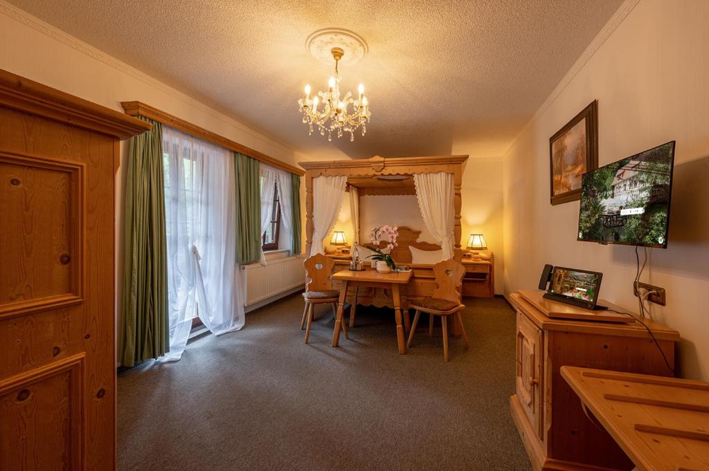 a living room with a table and a chandelier at Zur Margarethenmühle - Landgasthof und Waldhotel in Roßwein