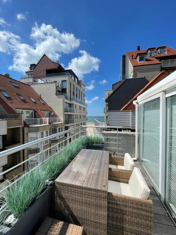 a balcony with a table and some buildings at Les abeilles in Knokke-Heist