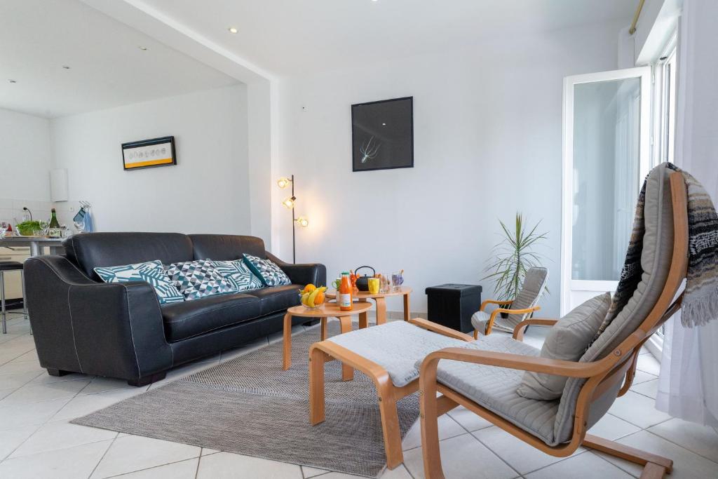 ein Wohnzimmer mit einem Sofa und einem Tisch in der Unterkunft Les Bleuets in Pléneuf-Val-André