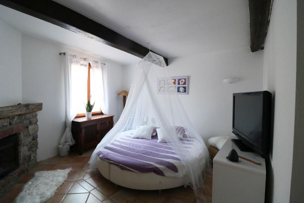 a bedroom with a bed with a mosquito net at Marie à Callas in Callas