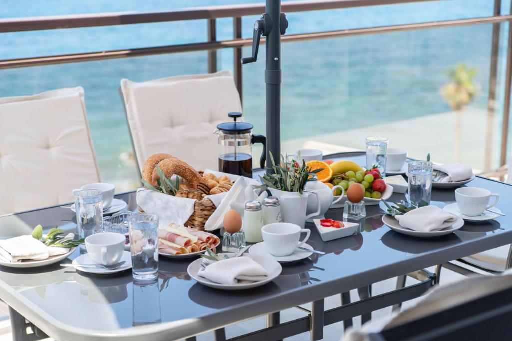 stół z jedzeniem i widokiem na ocean w obiekcie Blue Dreams - Spectacular Sea View Apartment in Athens w Atenach