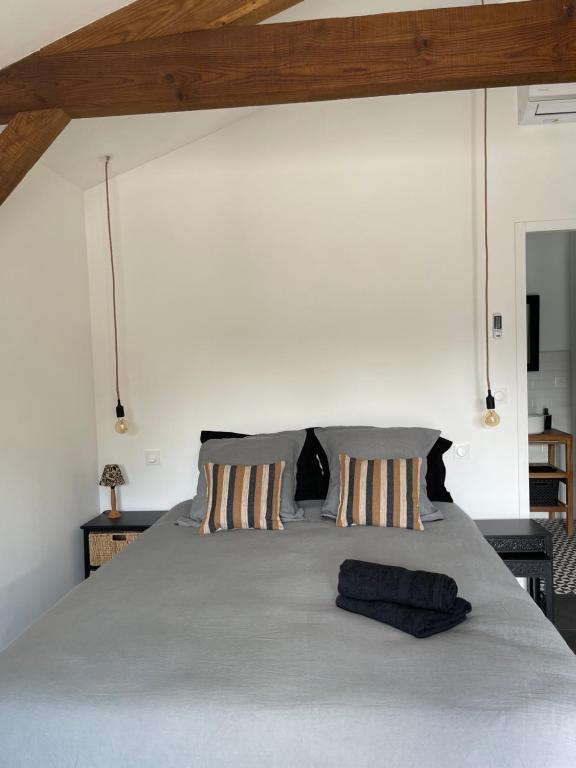 a bedroom with a large bed with two pillows at OSTAL 158 in Le Barp